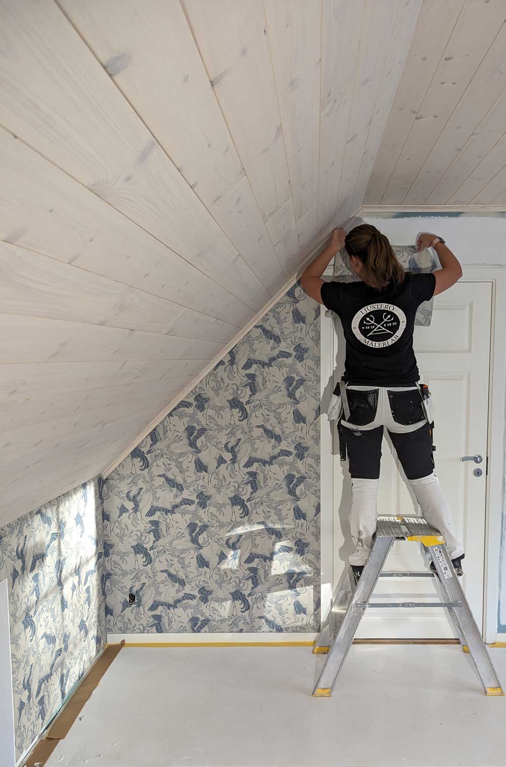 Anställd tjej målar en övervåning i villa